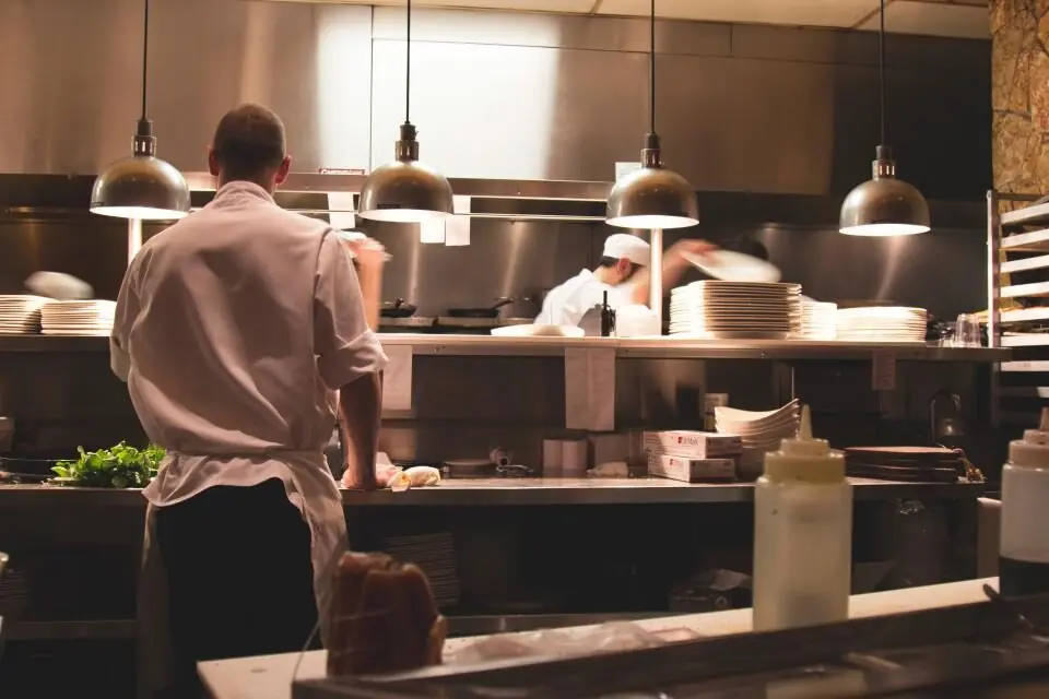 Two chefs working together at the counter of an open kitchen
